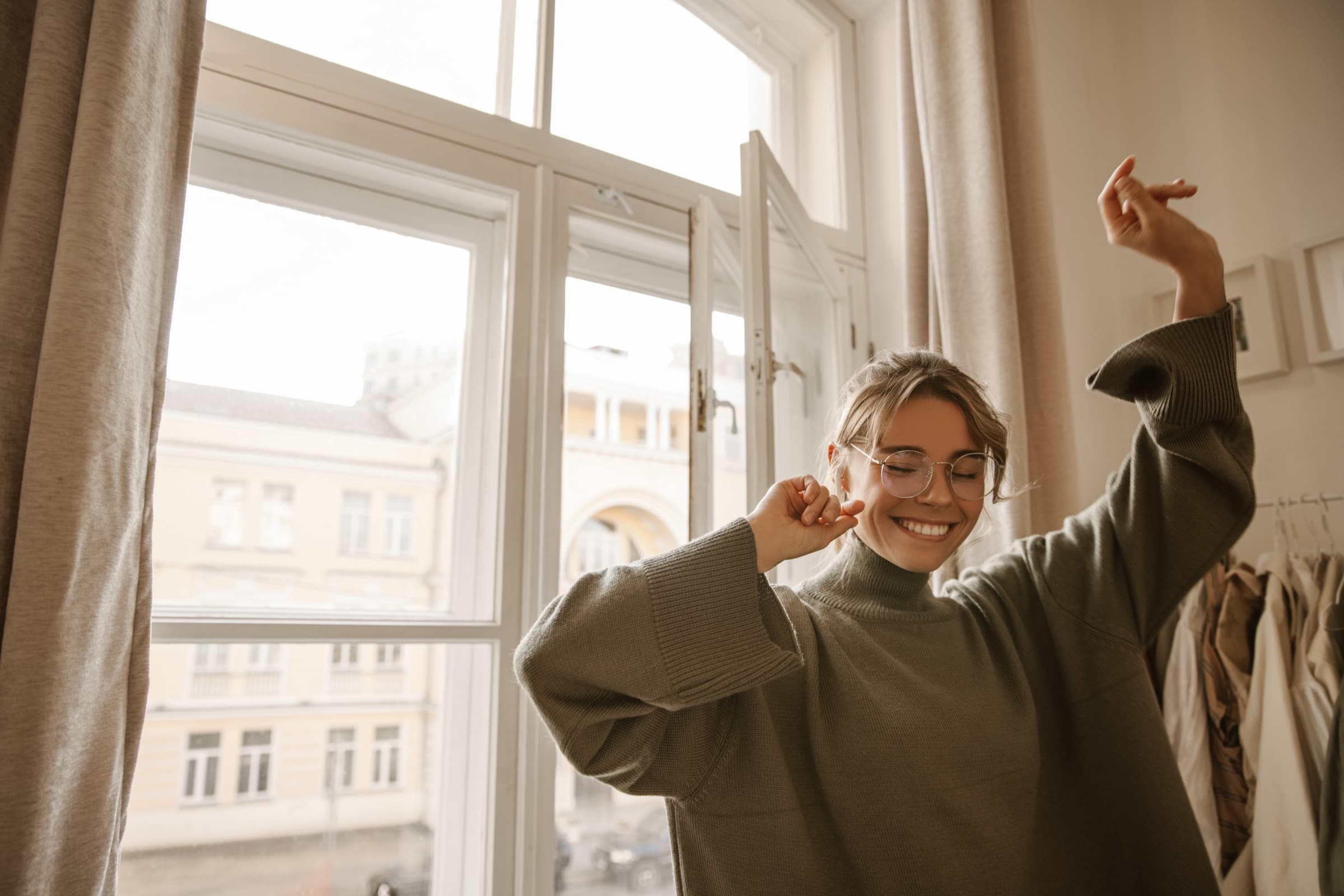 Frau tanzt entspannt am Fenster: Wer sein Werkzeug richtig gewählt hat, muss den EU AI Act nicht fürchten